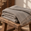 Grey wool lohi folded on a rustic wooden stool